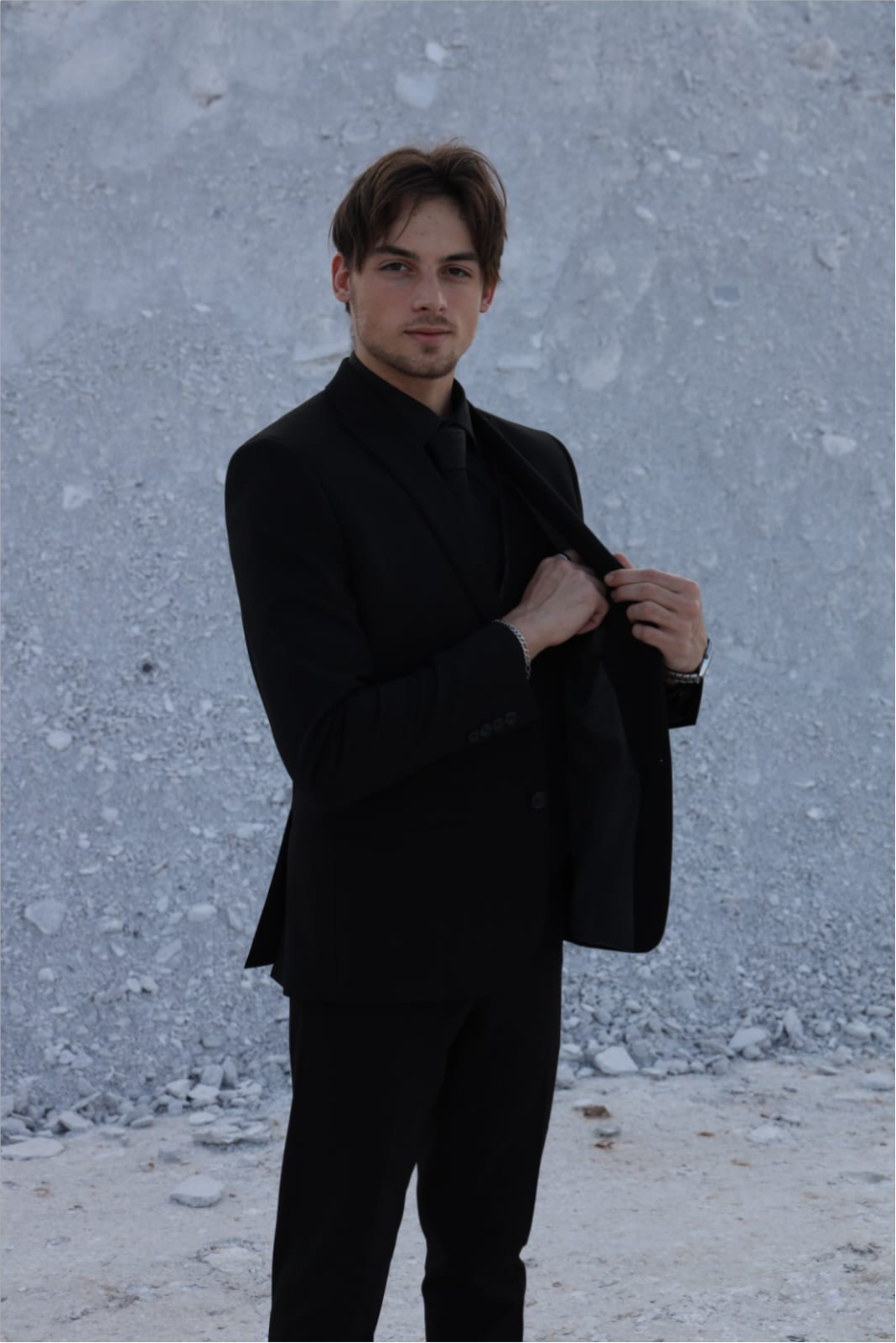 Corné, founder of Fradyn, wearing a black suit against a stone wall