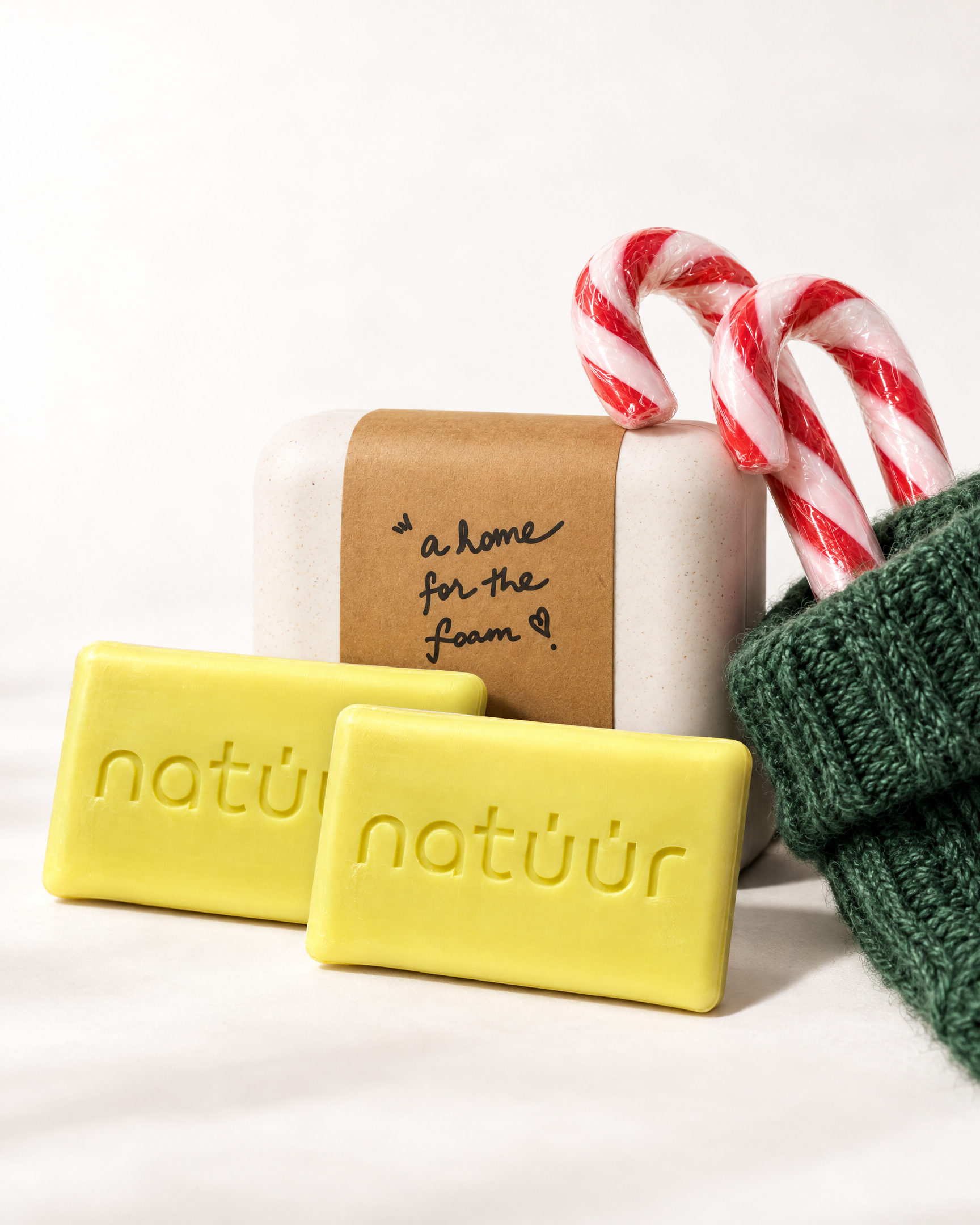 natüür Soap Buddy Kit: zwei Solid Soaps und eine Soap Box schauen aus einem salbeigrünen, gestrickten Weihnachtsstrumpf