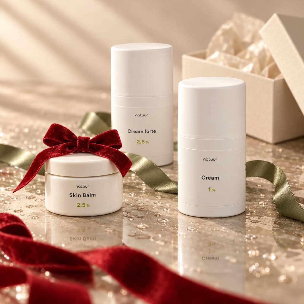 natüür Calm Skin Trio – Skin Balm, Cream und Cream forte mit salbeigrünem Band auf glänzender Fläche mit Wassertropfen