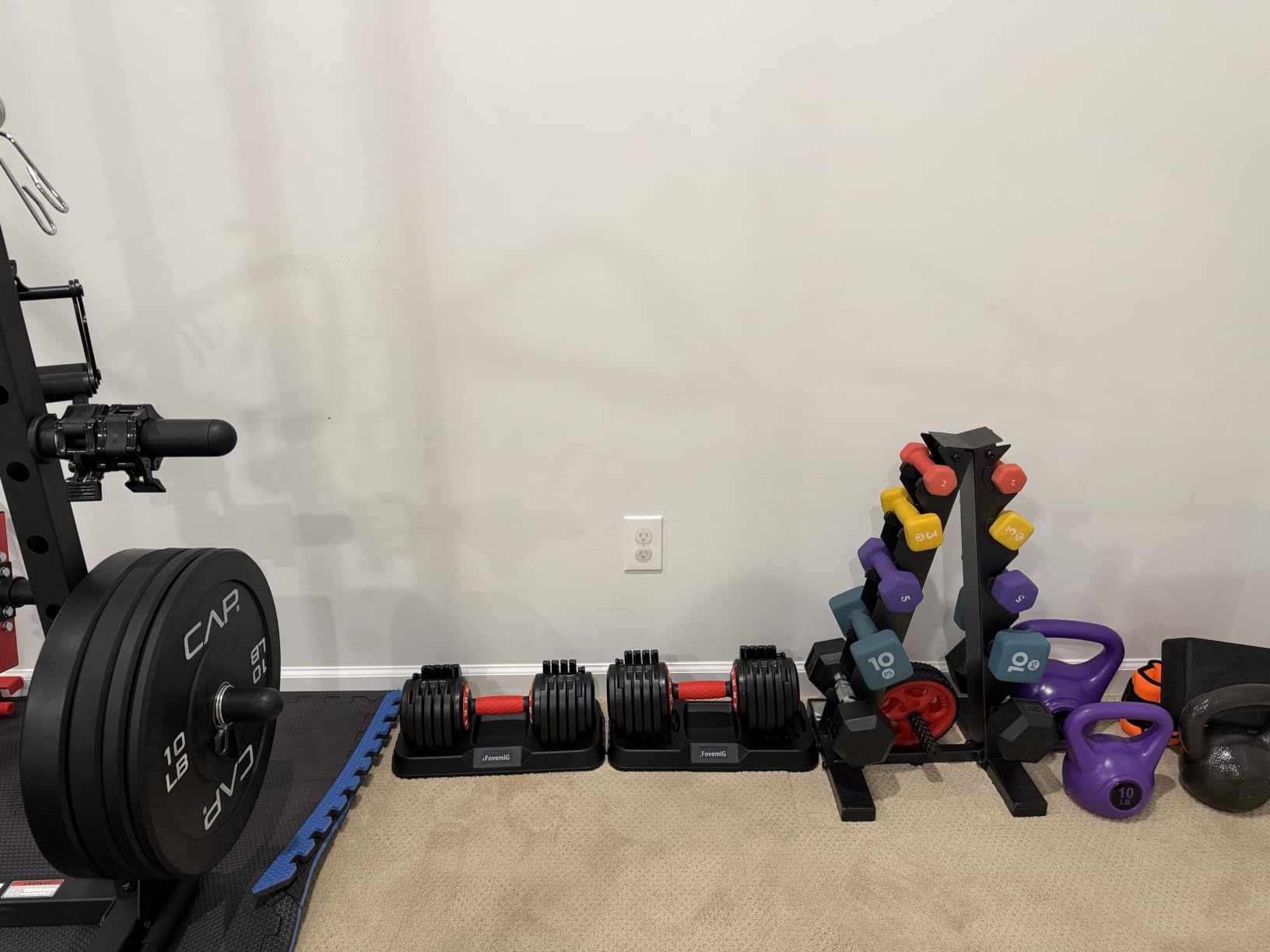 Customer photo: dumbbells stored beside a sofa