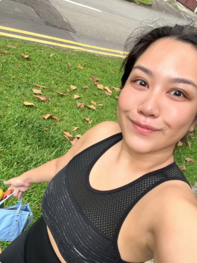 Portrait of Lina, smiling outdoors after a workout
