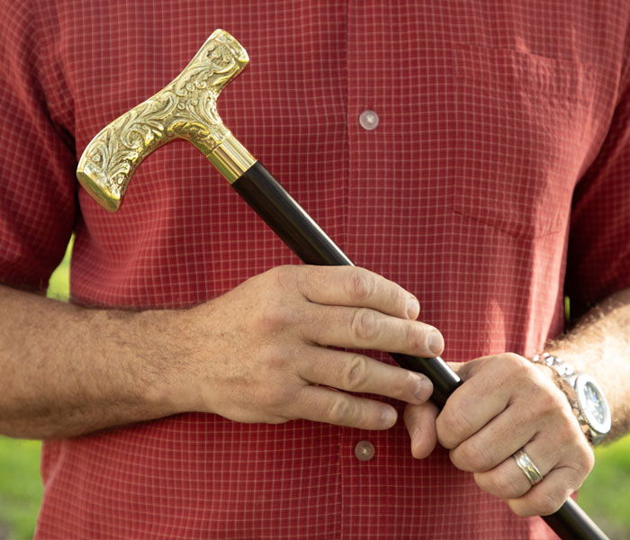 man holding brass cane