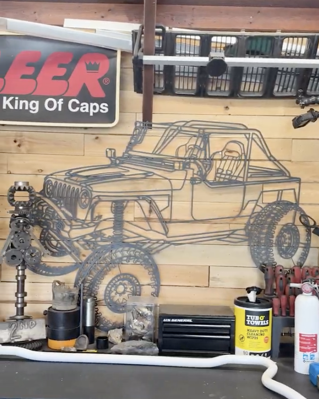 Smiling customer holding a framed car silhouette print in his garage