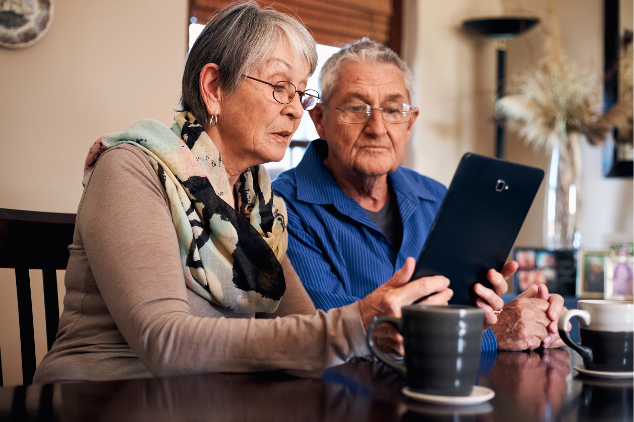 Older adult man and woman with dementia at home setting up safety tech.