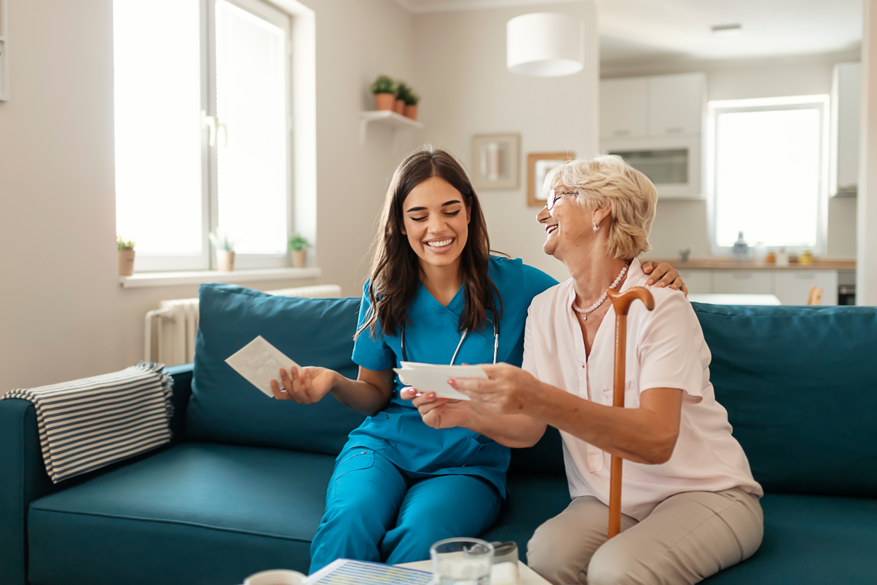 Caregiver with older adult with dementia in living room.