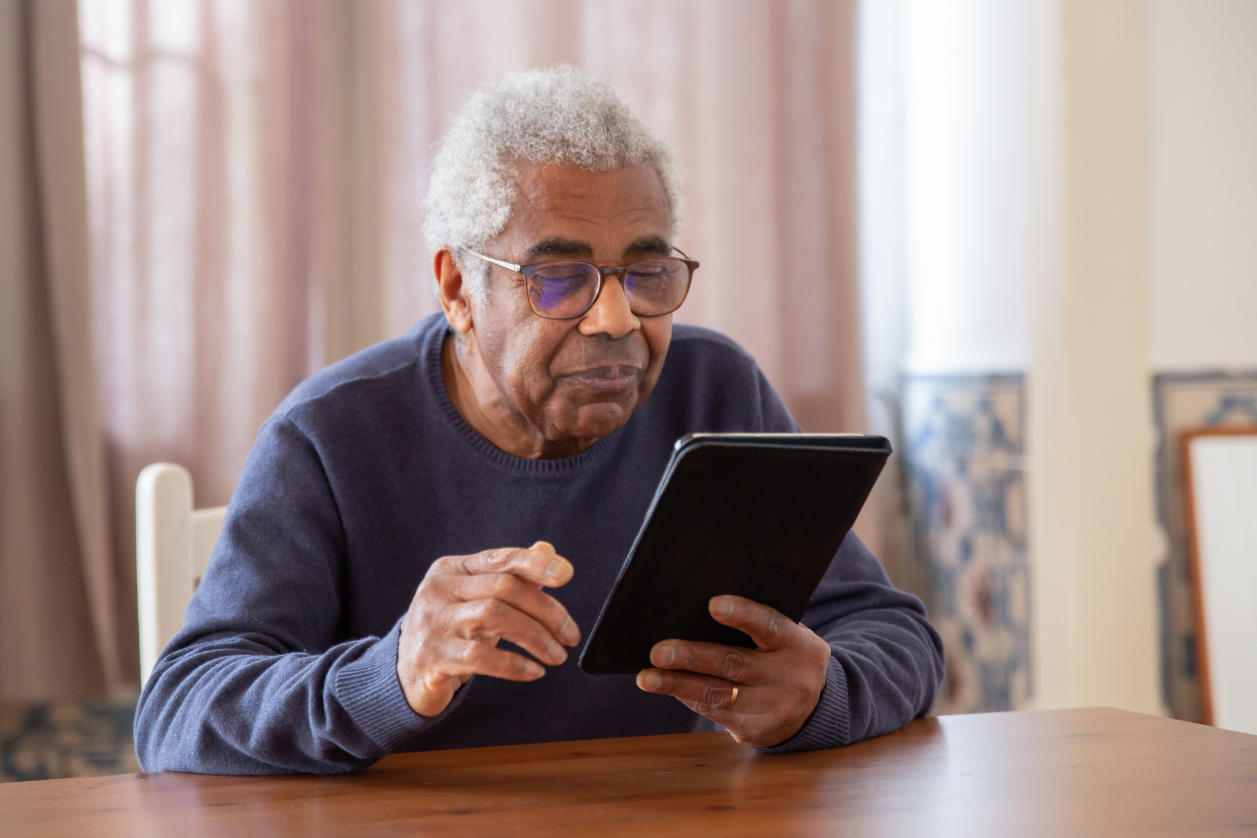Older adult in senior living using some digital signage to stay co