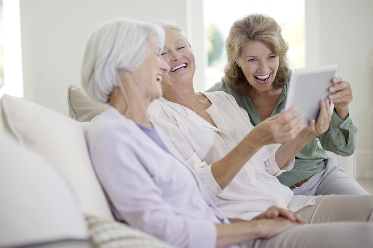 Older adults looking at a dementia reminder board in a living room.