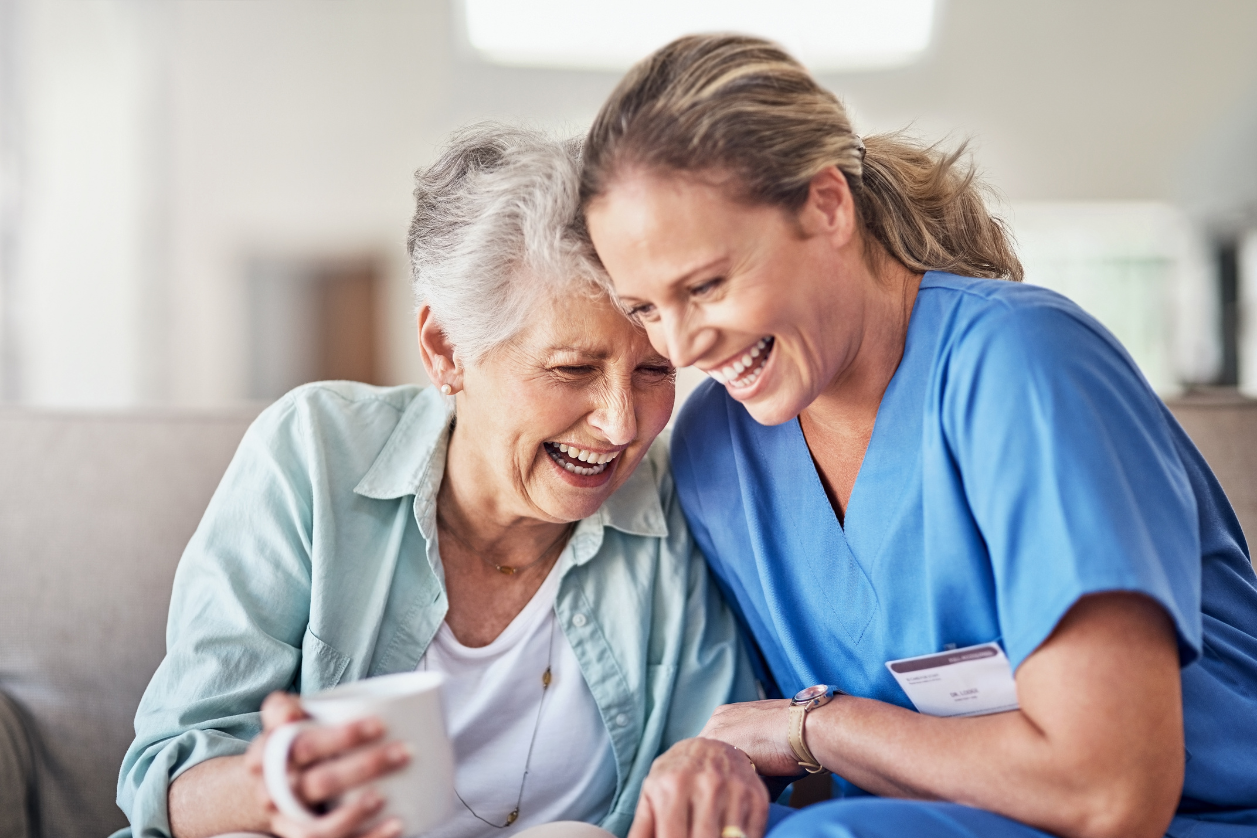 Caregiver comforting an older senior adult with a hug.