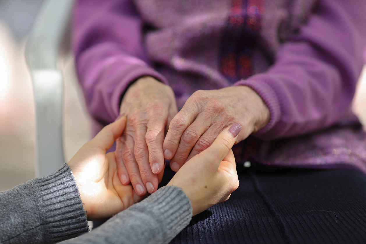 Caregiver holding hands of person with dementia
