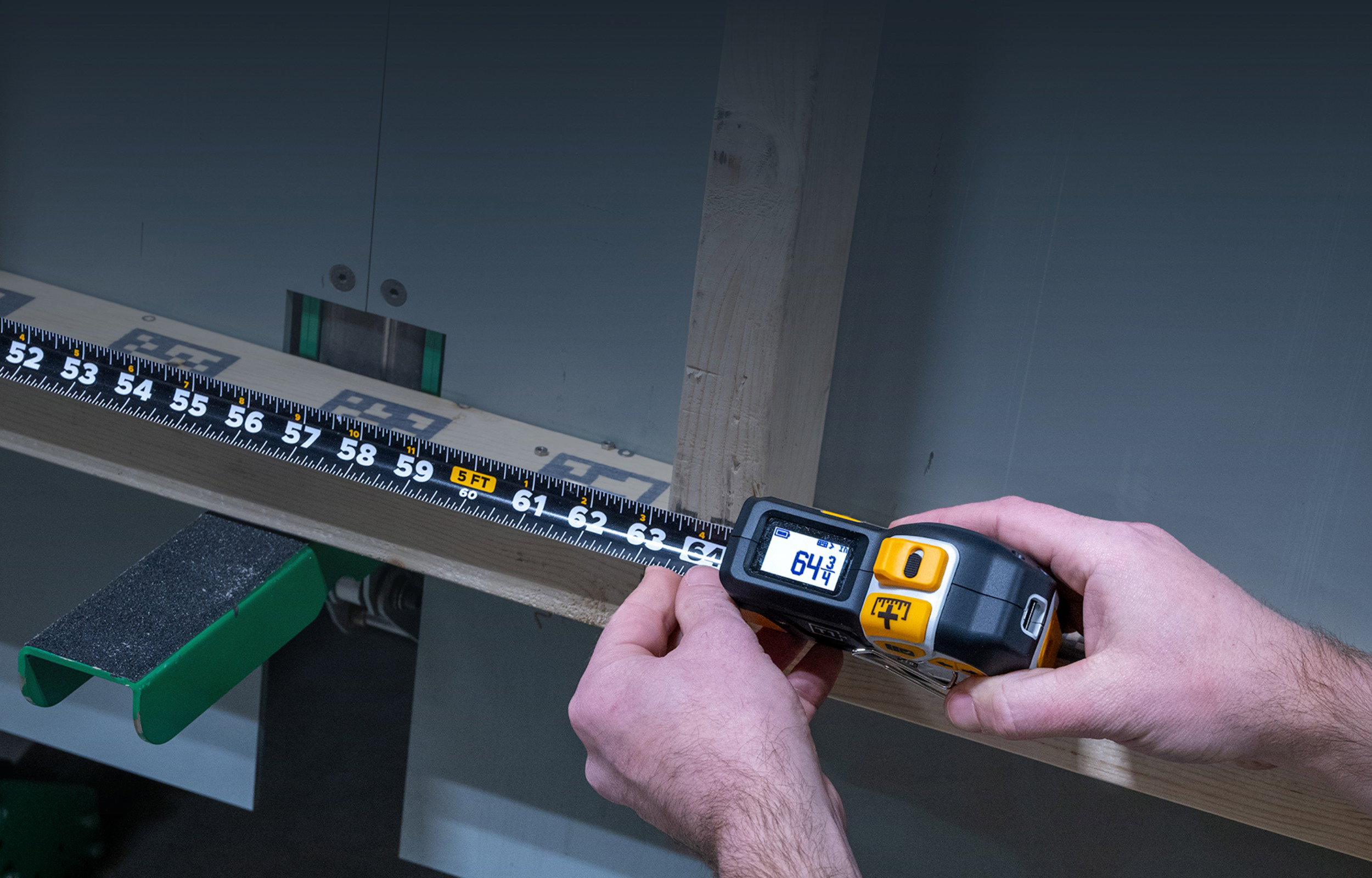 Hands holding a tape measure showing 64 inches against a wooden board