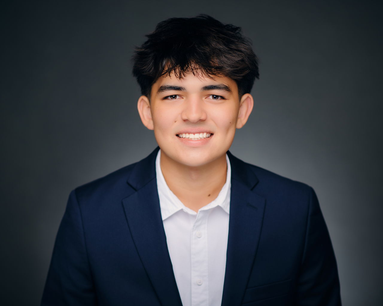 Young man dressed professionally smiling.