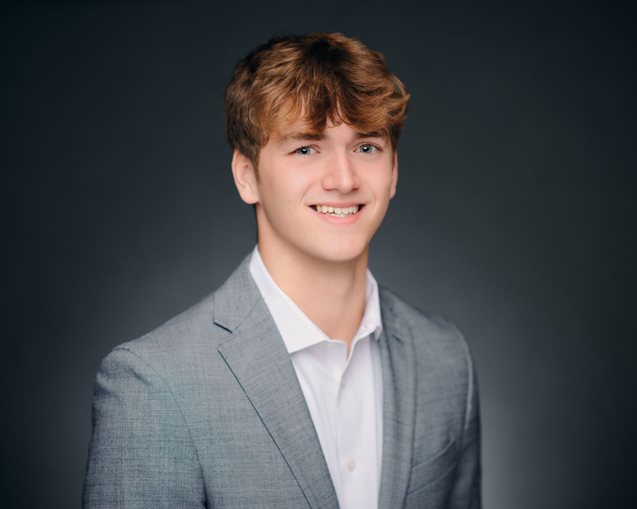 Young man dressed professionally smiling.