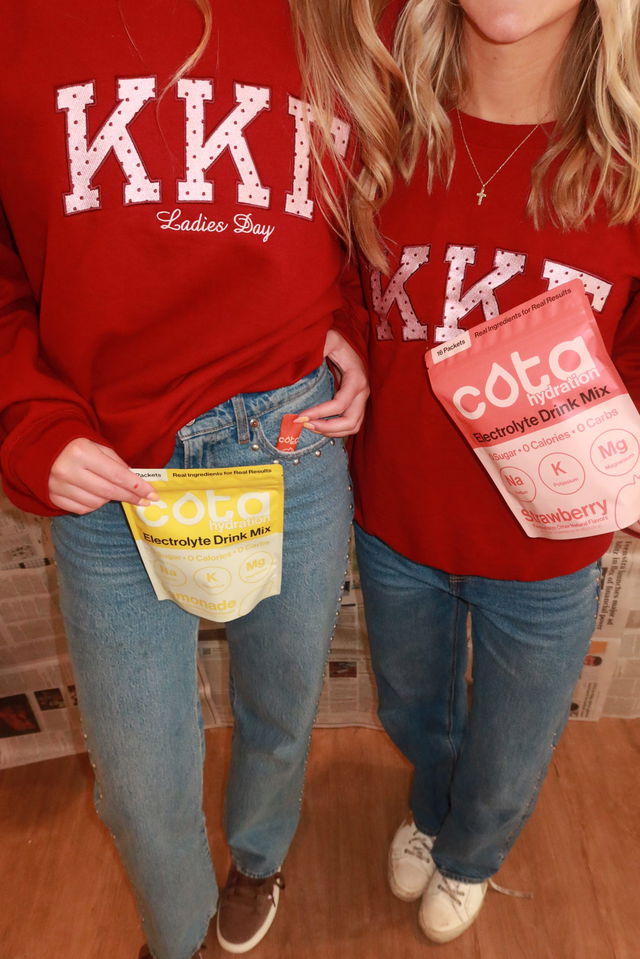 Two women holding a bag of lemonade and strawberry cota hydration electrolytes