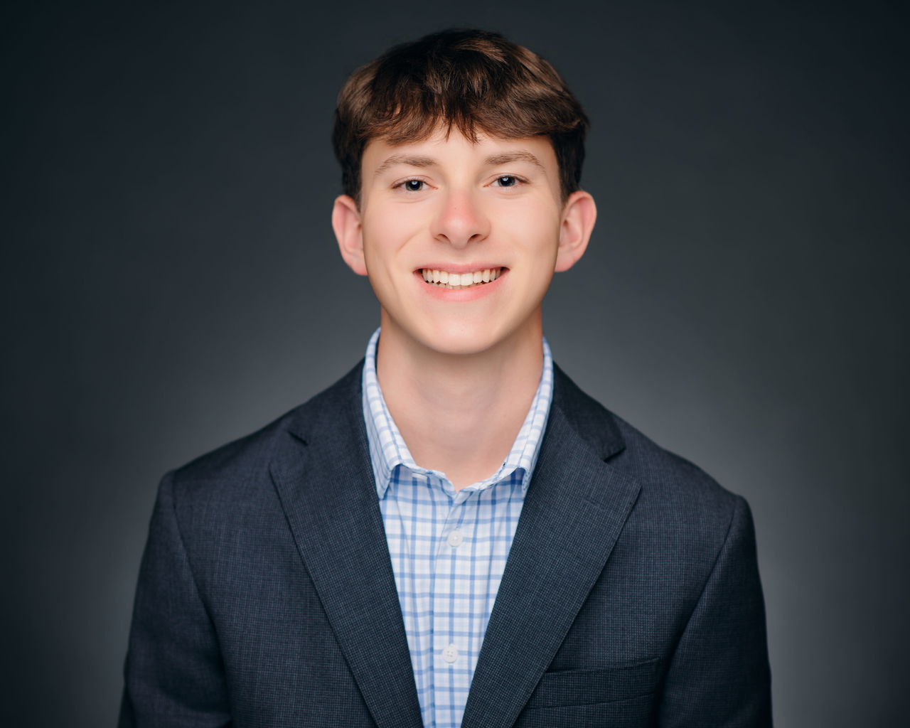 Young man dressed professionally smiling.