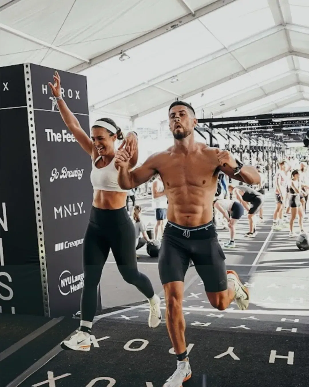 Hyrox athlete couple crossing finish line together wearing AirMag Pro magnetic nasal strips