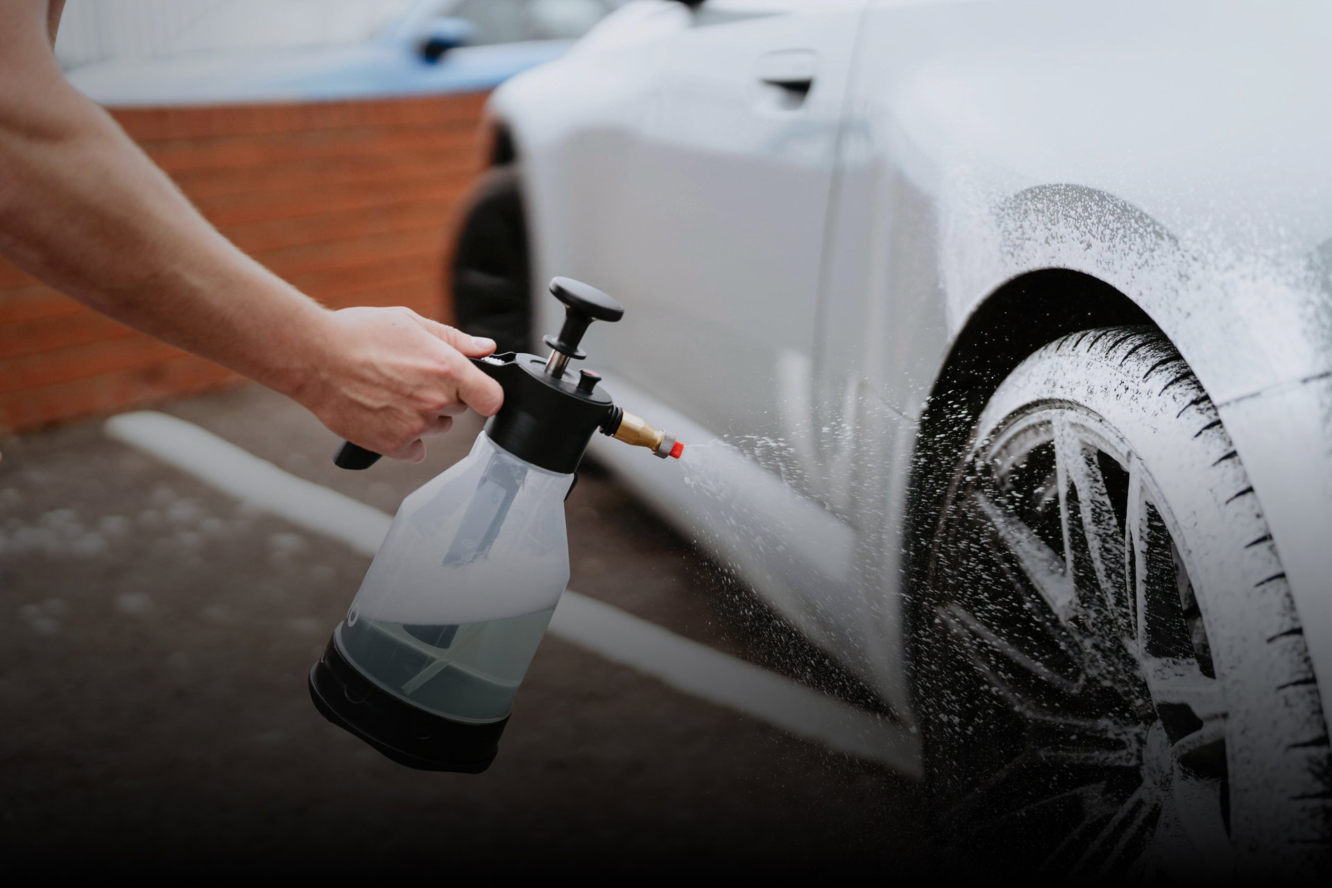 Hydro spray bottle covering a car wheel in snow foam
