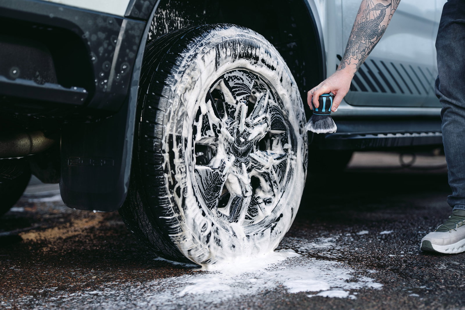 Snow foam dwelling over an alloy wheel with the Hydro Orb Brush ready in hand