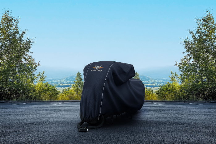 A covered motorcycle under clear sun