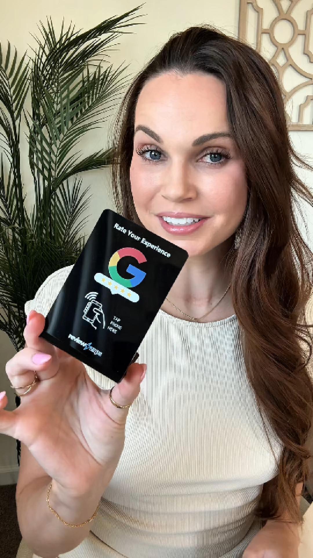 Brook Skylers, owner of Glow Salon, holding a Review Zaps NFC review stand