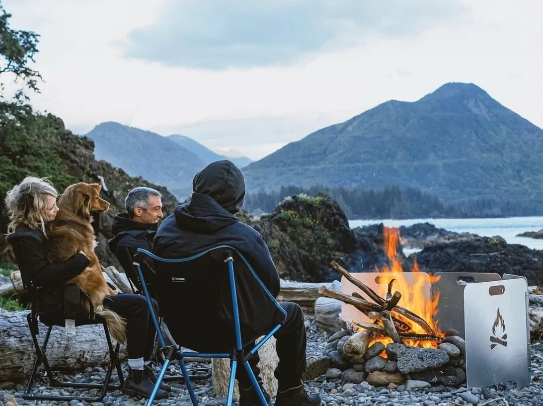 Family with dog, next to fire reflector