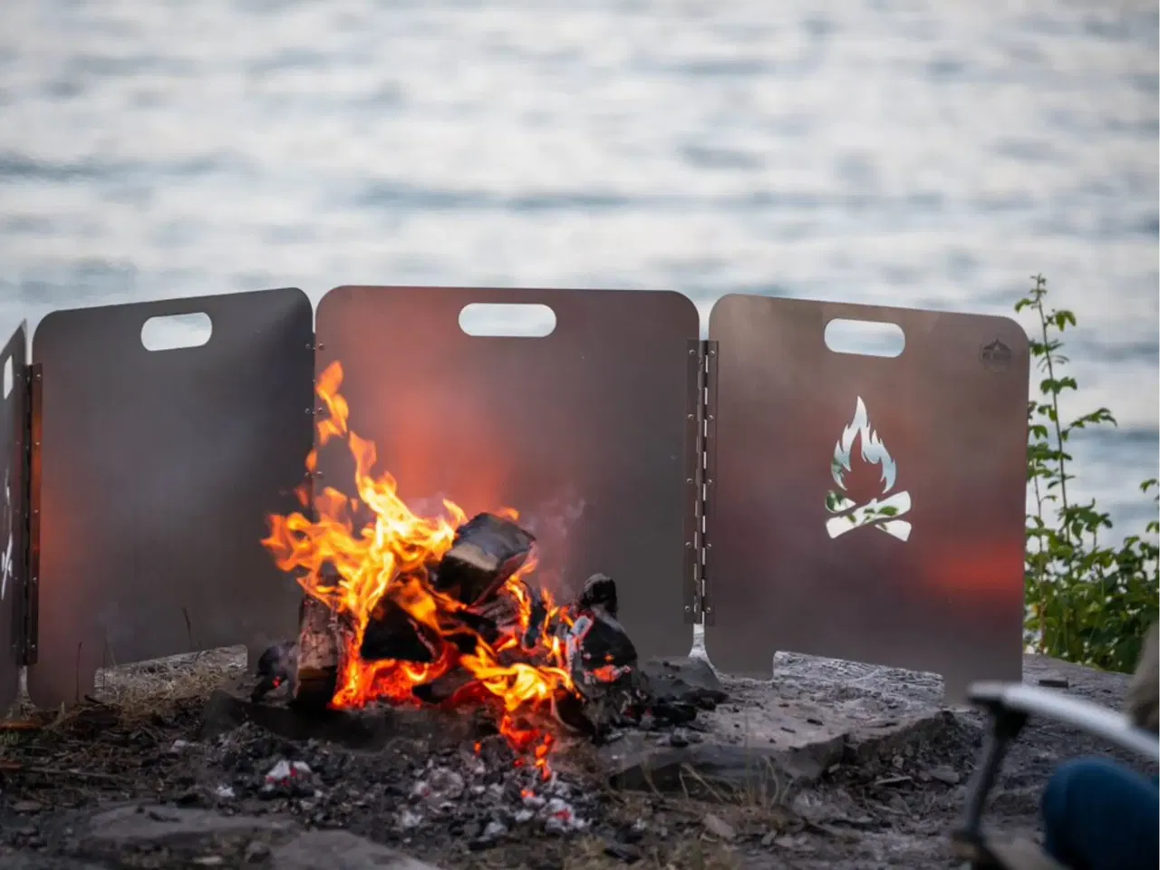 A photo of the fire reflector with fire right by the ocean