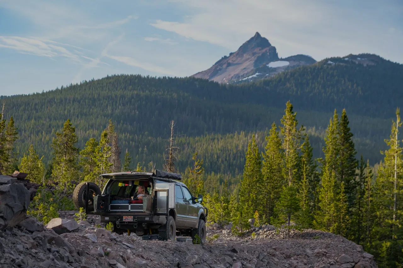 Women in overlanding car over looking mountain and forest