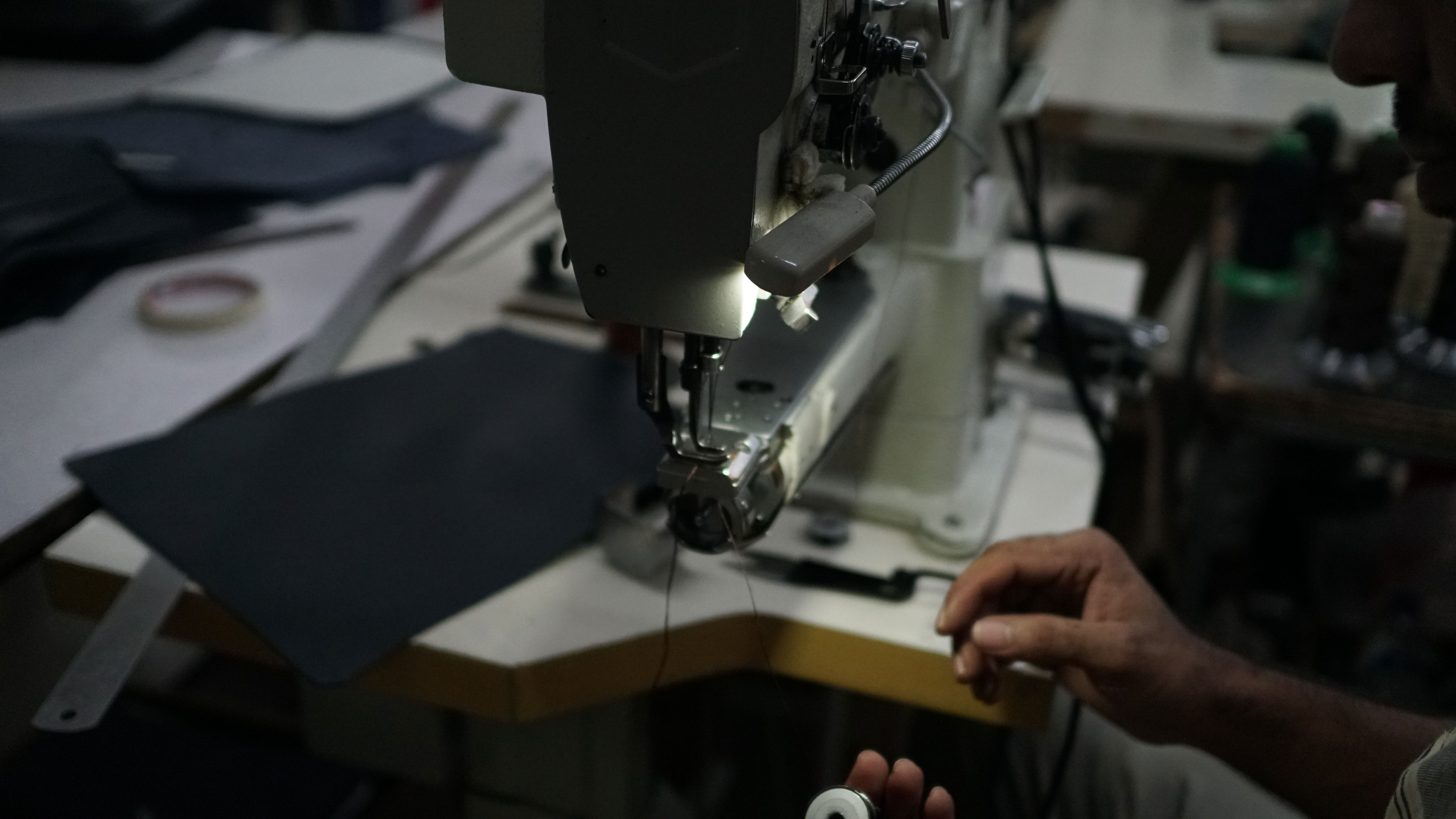 Artisan stitching leather in the workshop
