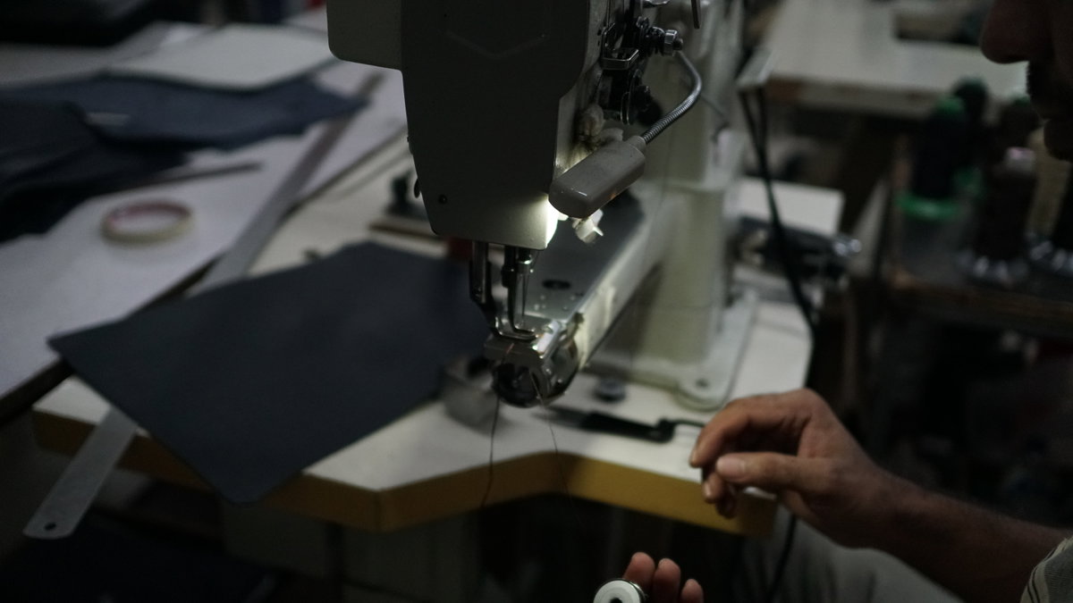 Artisan hand-stitching full-grain leather in the workshop