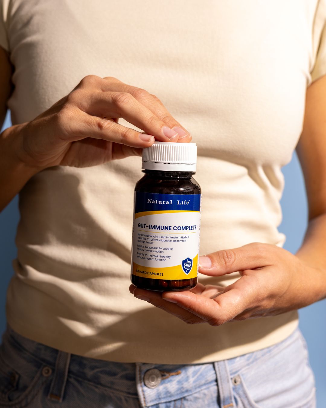 Open probiotic capsules with fine powder spilling onto cream linen