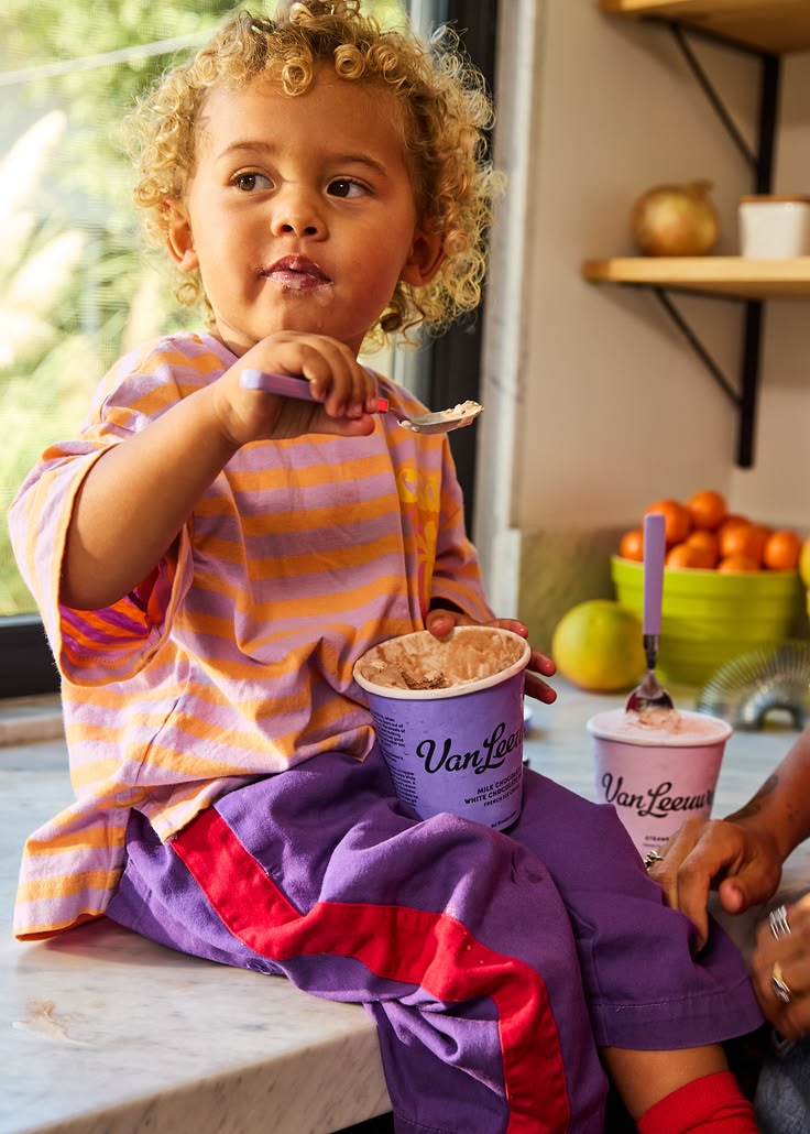Child enjoying a spoonful at the kitchen bench