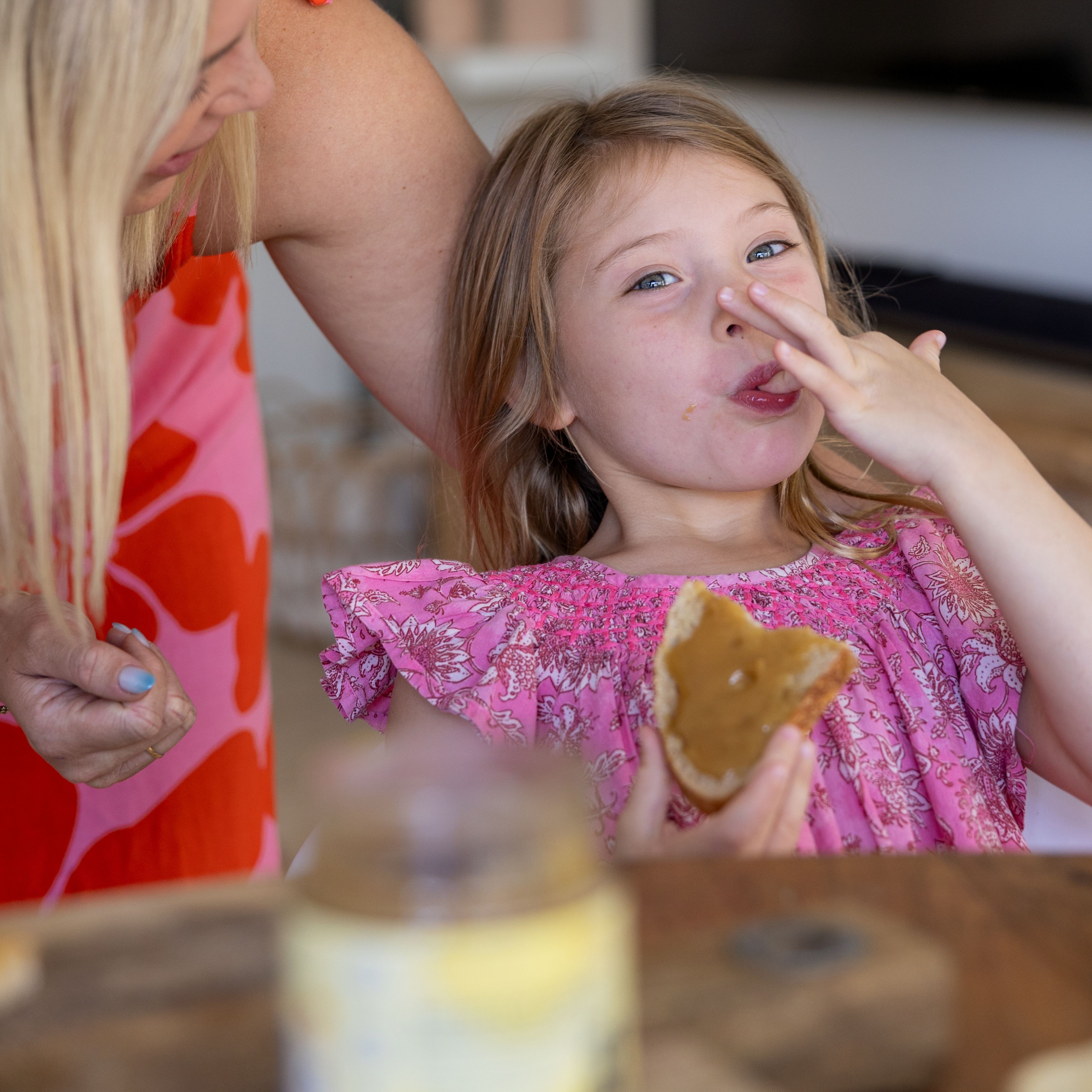 Girl licking Superfood Spread off her fingers while eating toast