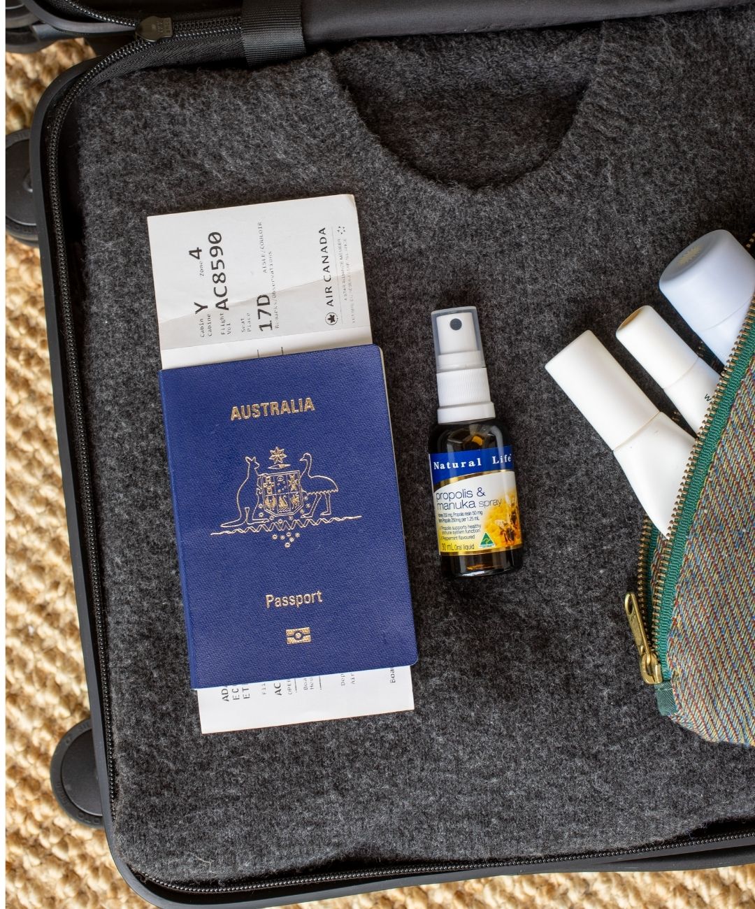 Natural Life Propolis & Manuka Honey Spray packed in a suitcase next to an Australian passport and boarding pass