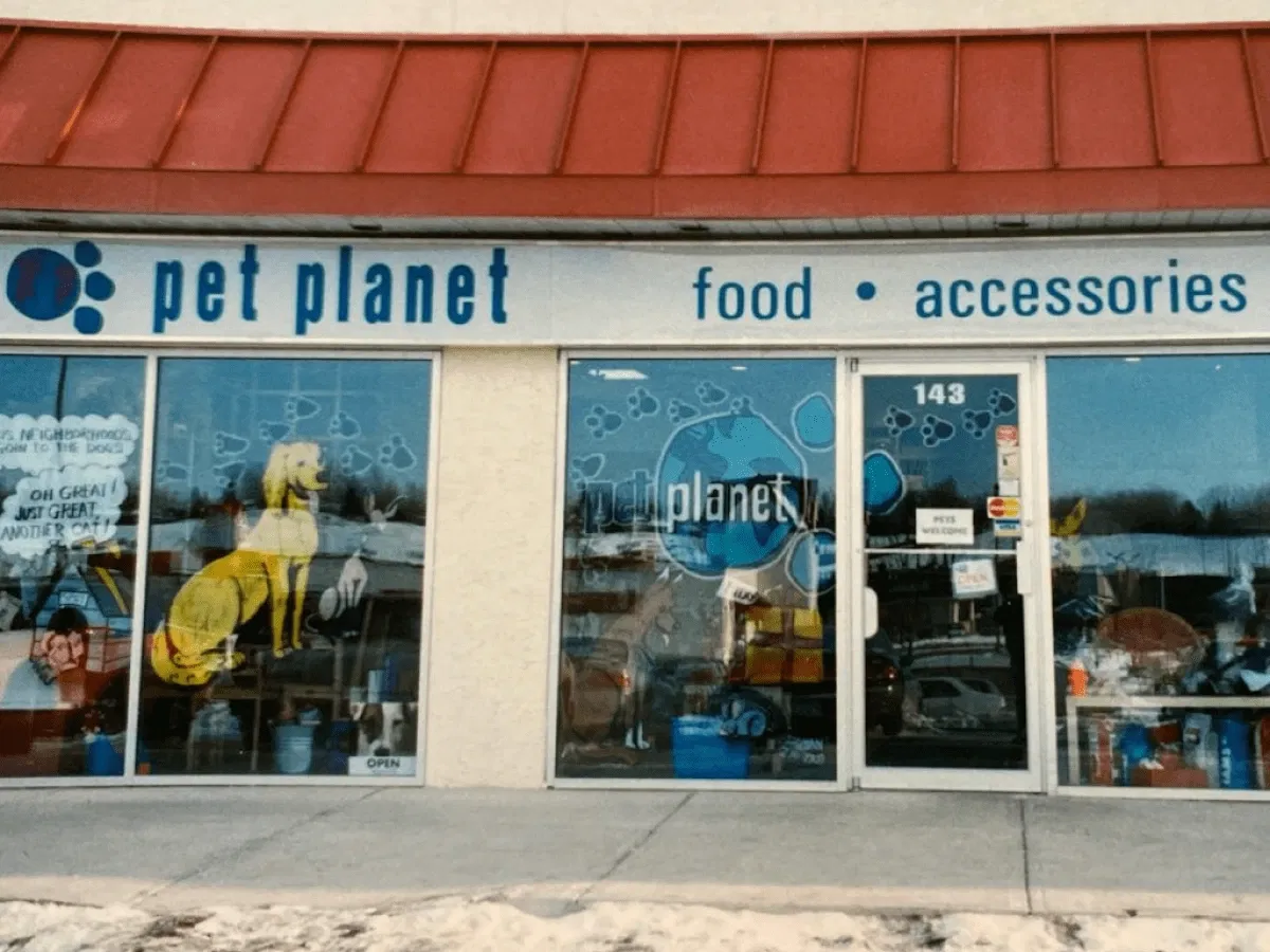 Pet Planet Toronto storefront with red roof and large glass windows featuring playful dog illustrations