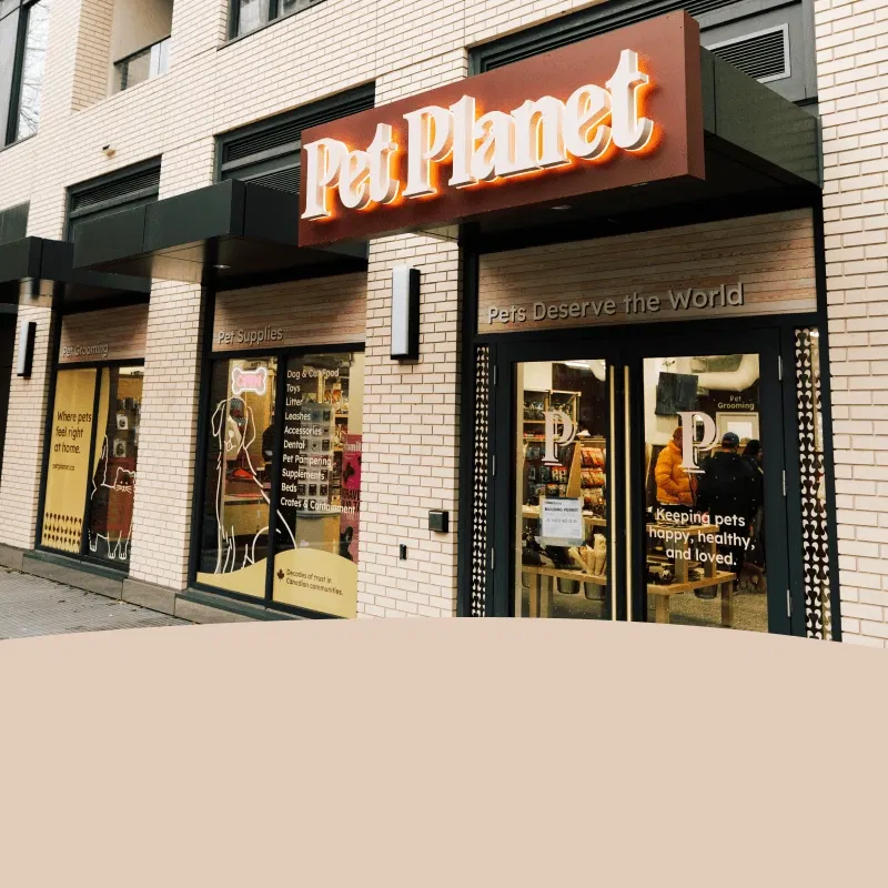 Exterior of Pet Planet pet supplies and grooming store with large sign and glass doors