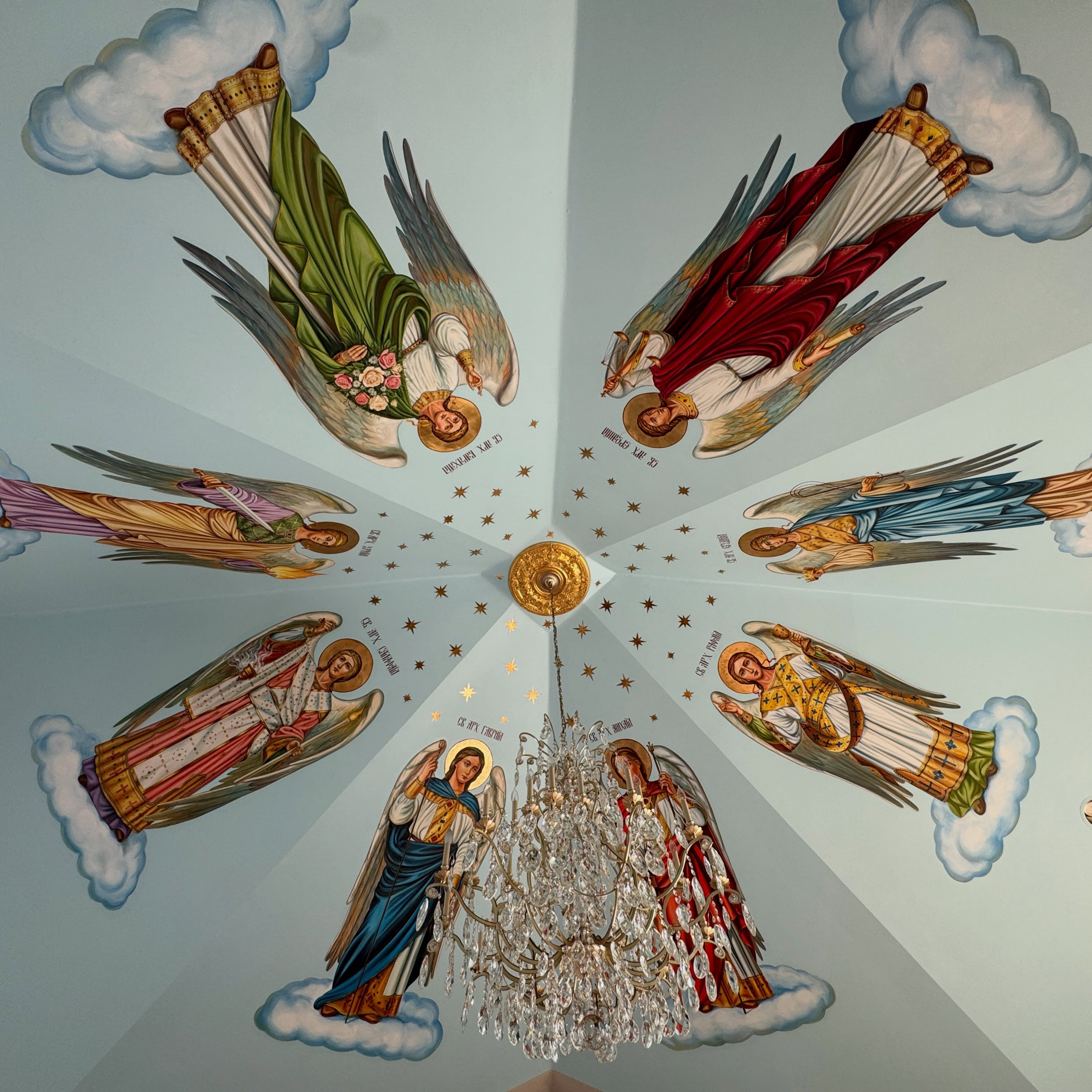 Ceiling fresco at Holy Trinity Ukrainian Orthodox Church: haloed archangels on clouds circling a gilded rosette beneath a sky of gold stars
