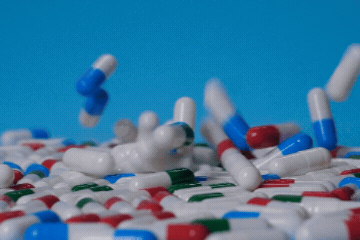 Colorful capsules and pills tumbling onto a pile