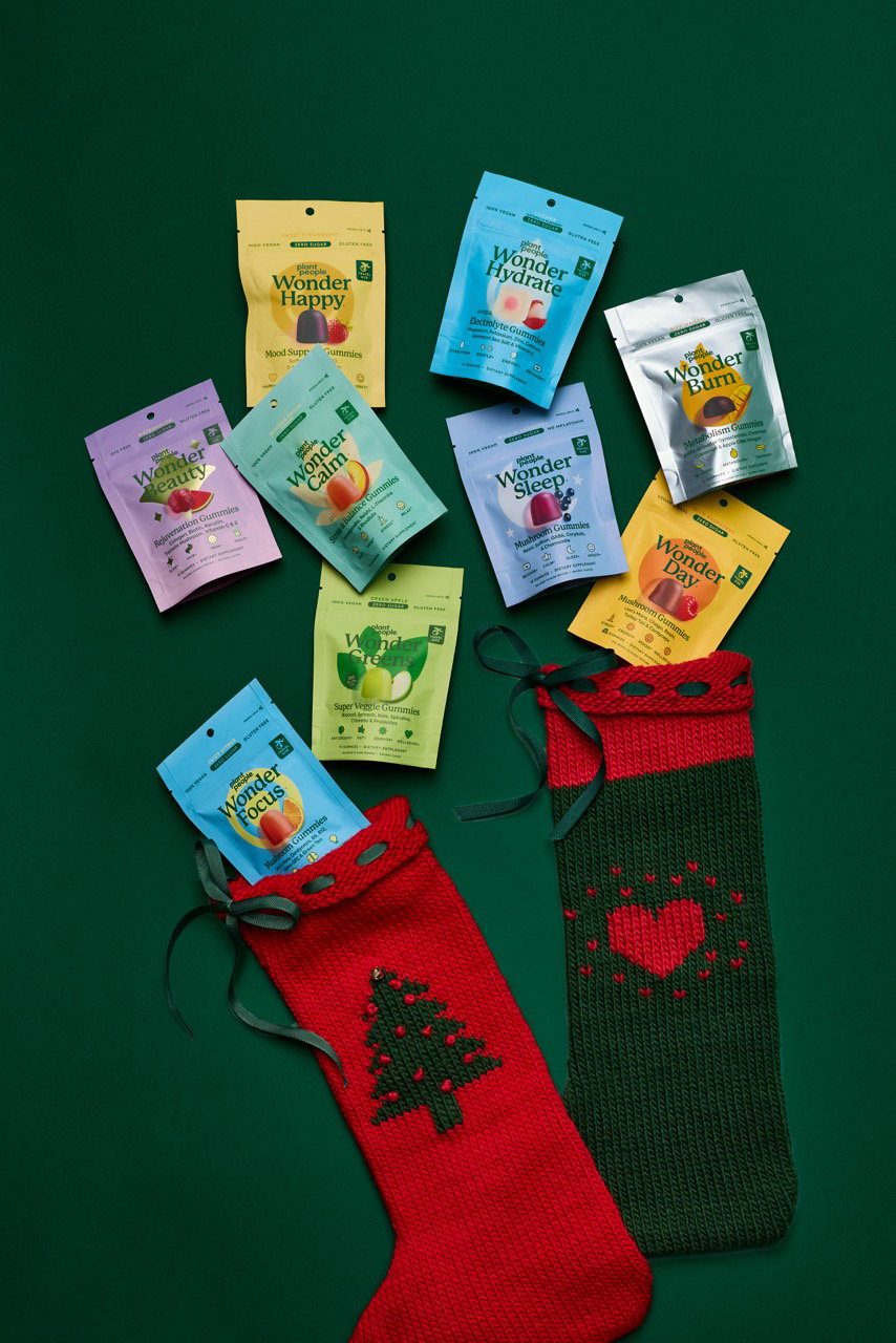Trial-size Plant People gummy pouches tucked into red and green knit stockings with gold ribbon