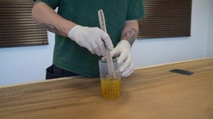 Stirring the two components of Oil Plus 2C together in a measuring jug