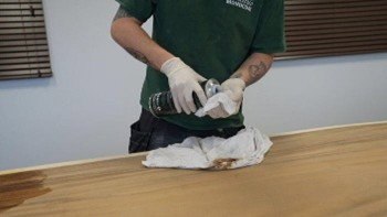 Cleaning the sanded tabletop with a cloth and Cleaner