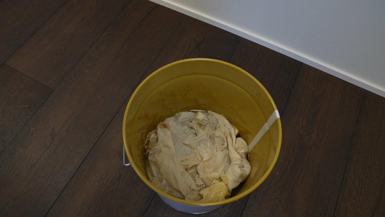 Bucket of water with used cloths and pads soaking before disposal