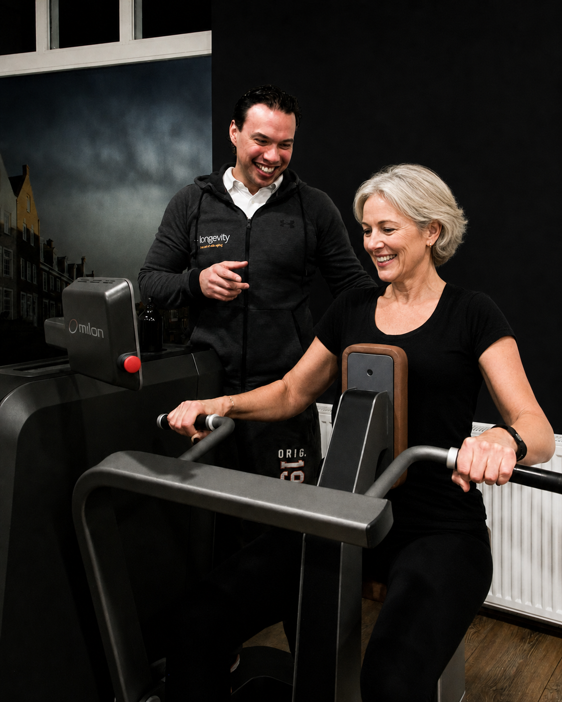 Bewegingsspecialist begeleidt een vrouw tijdens haar training op een Milon-toestel