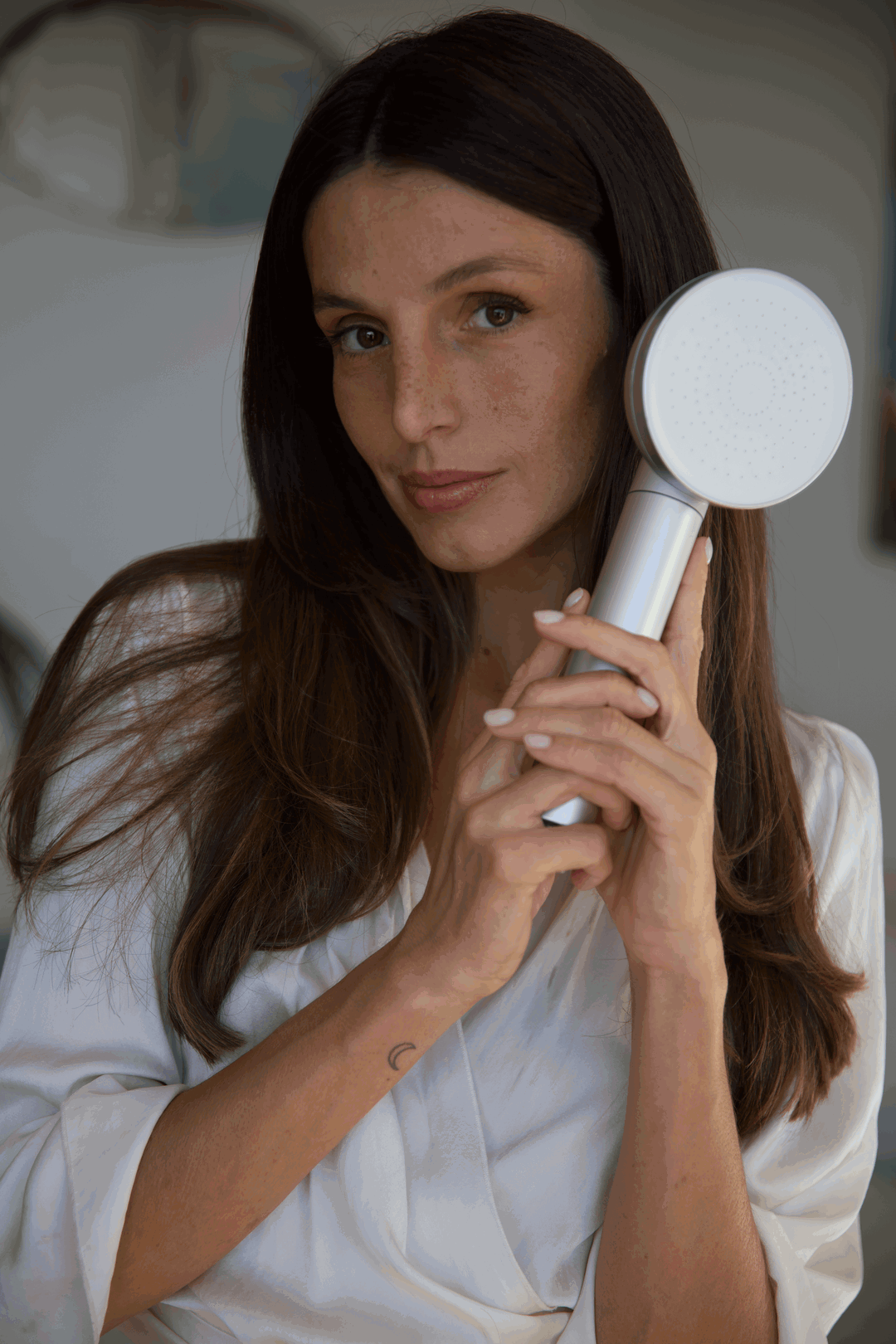 Cliente tenant son pommeau filtrant Seoni contre son visage