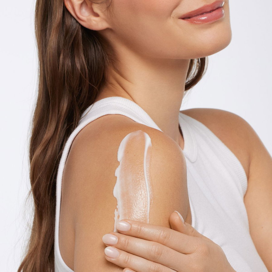 Femme appliquant une crème hydratante sur la joue