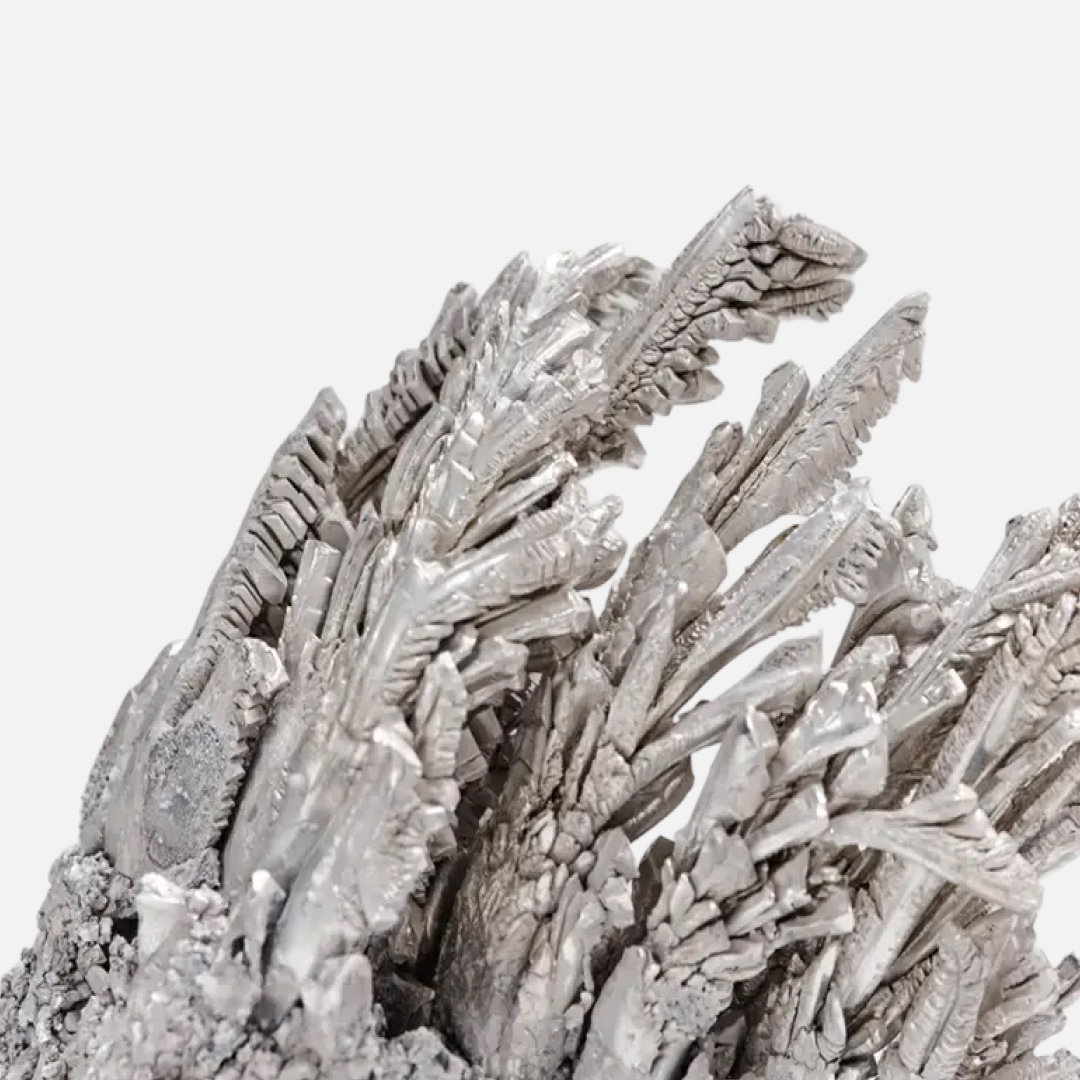 Cristales de magnesio de aspecto metálico y plateado sobre fondo claro