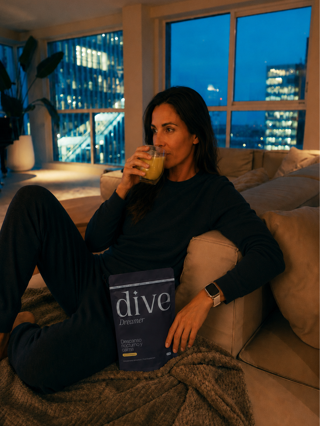 Mujer sentada en el salón al anochecer tomando su bebida de Dive Dreamer junto a la bolsa del producto