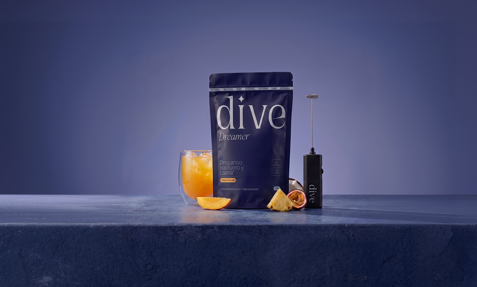 Bolsa de Dive Dreamer junto a un vaso con la bebida preparada y un espumador