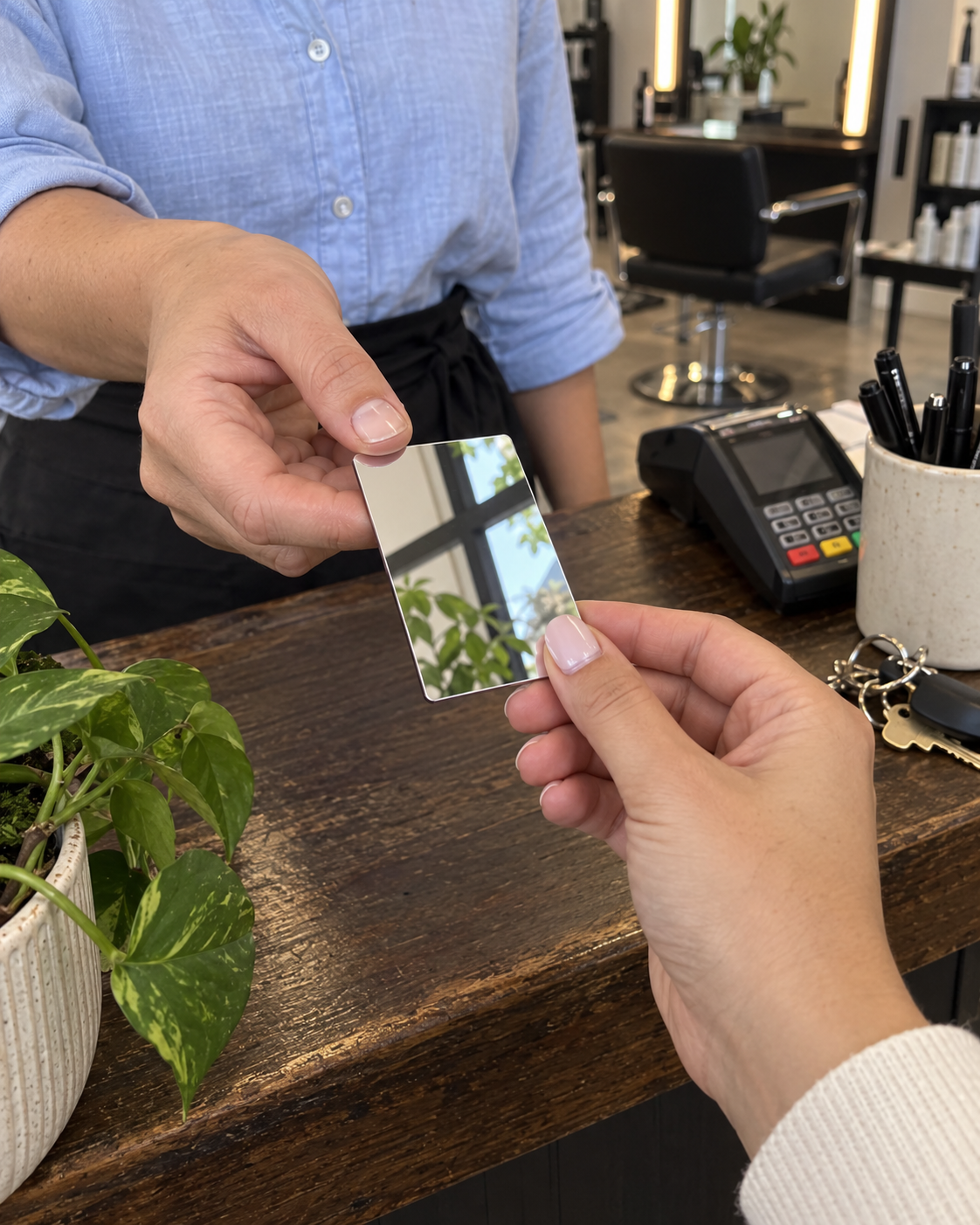 Une petite carte miroir remise à une cliente au comptoir du salon.