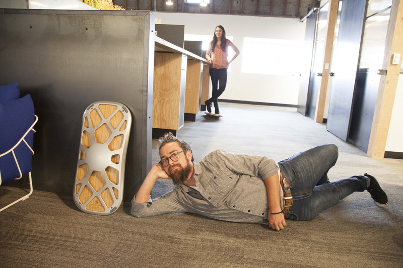 An Original deck propped against a desk in an open office while a colleague walks through the space on another deck