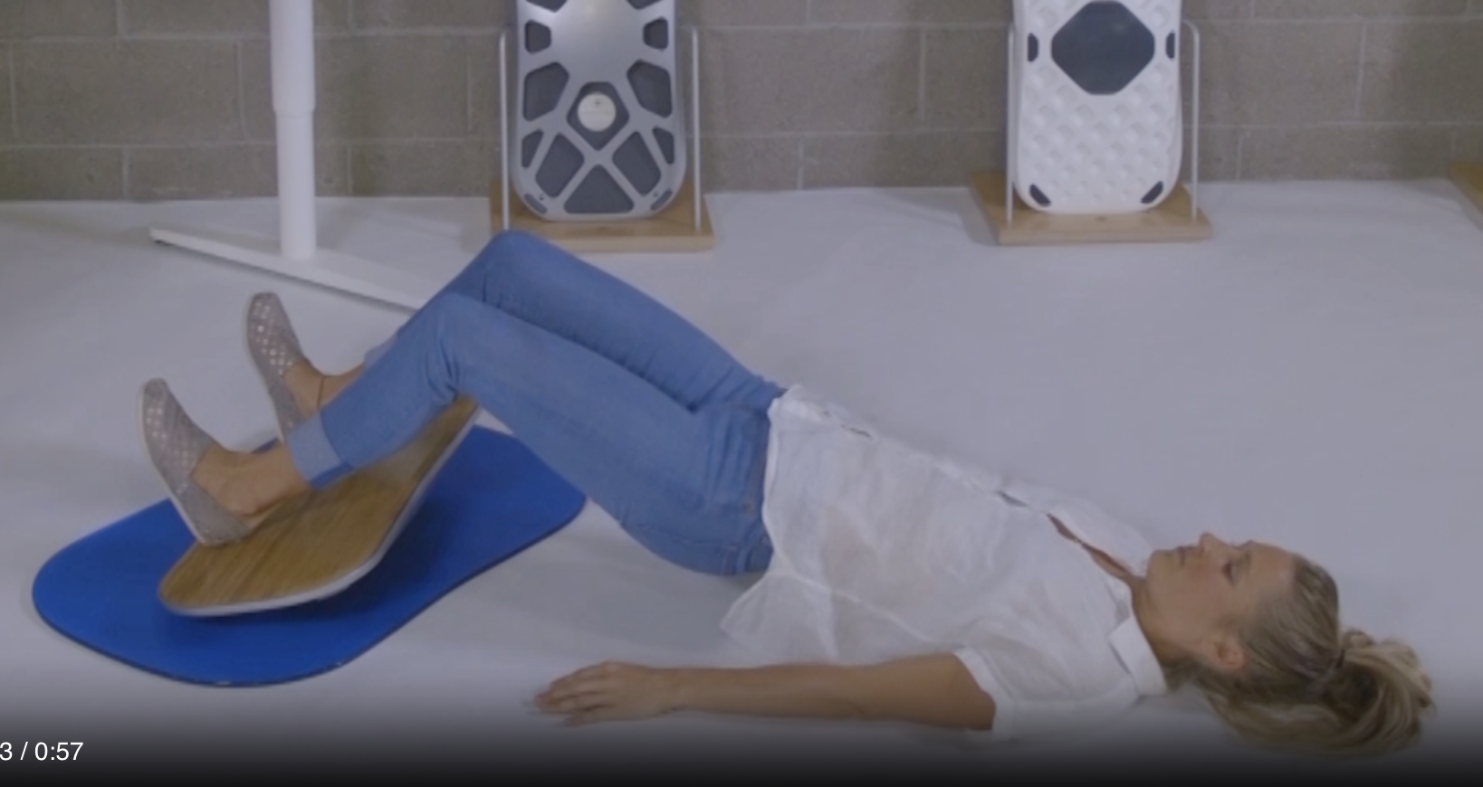 Hamstring bridge exercise with feet on a FluidStance balance board, from Pop-Up Workout Episode 2