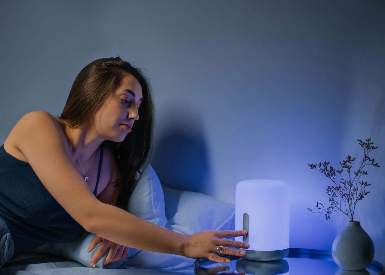 Vrouw in bed die er energierijk uitziet nadat ze een nacht goed heeft geslapen in een zacht bed
